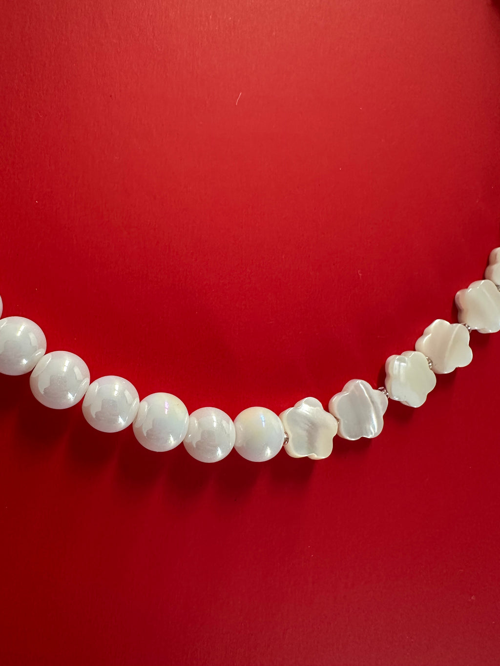 Collier Luna posé sur une nappe vichy avec des boucles d'oreilles