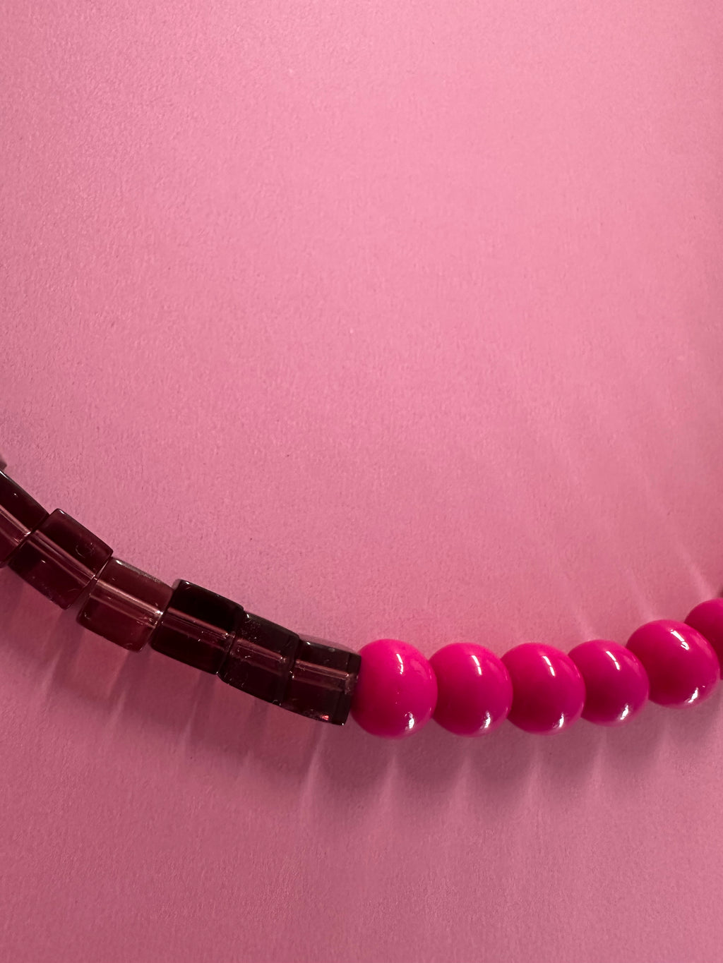 Gros plan du Collier Grenadine – détail perles bordeaux et fuchsia