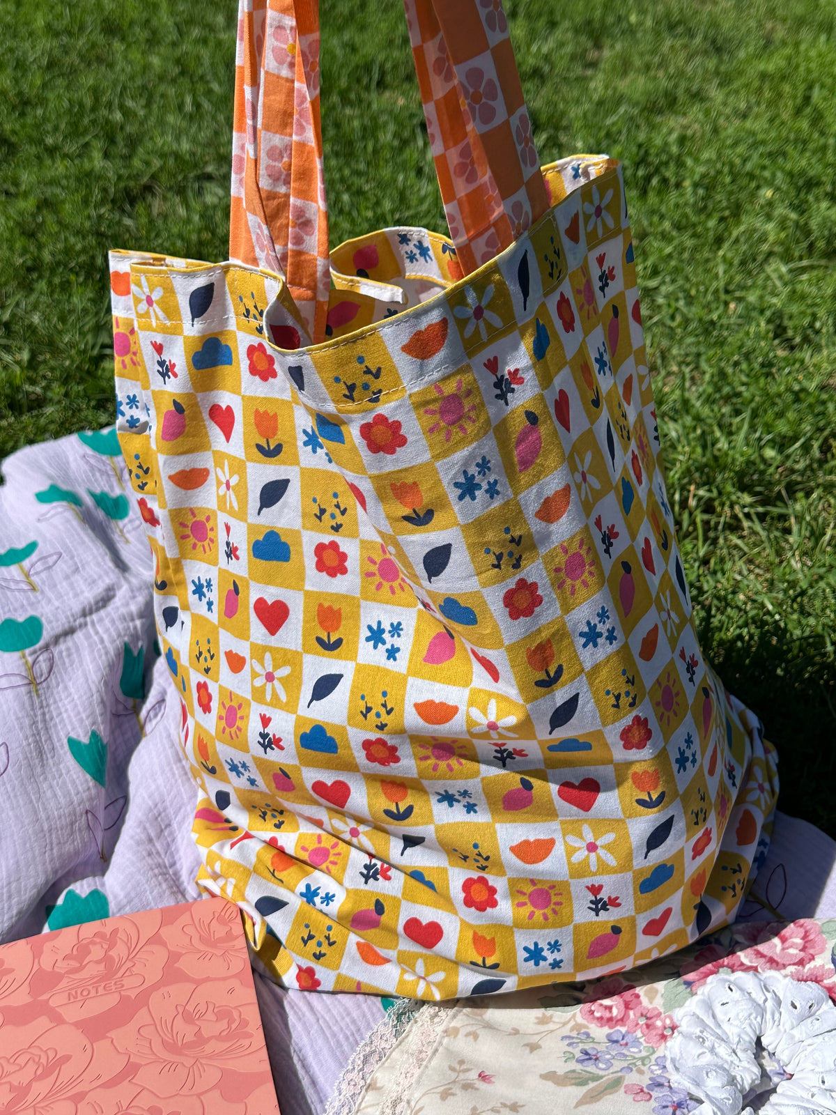 Sac Lisette damier jaune fleuri vu de face, anses orange