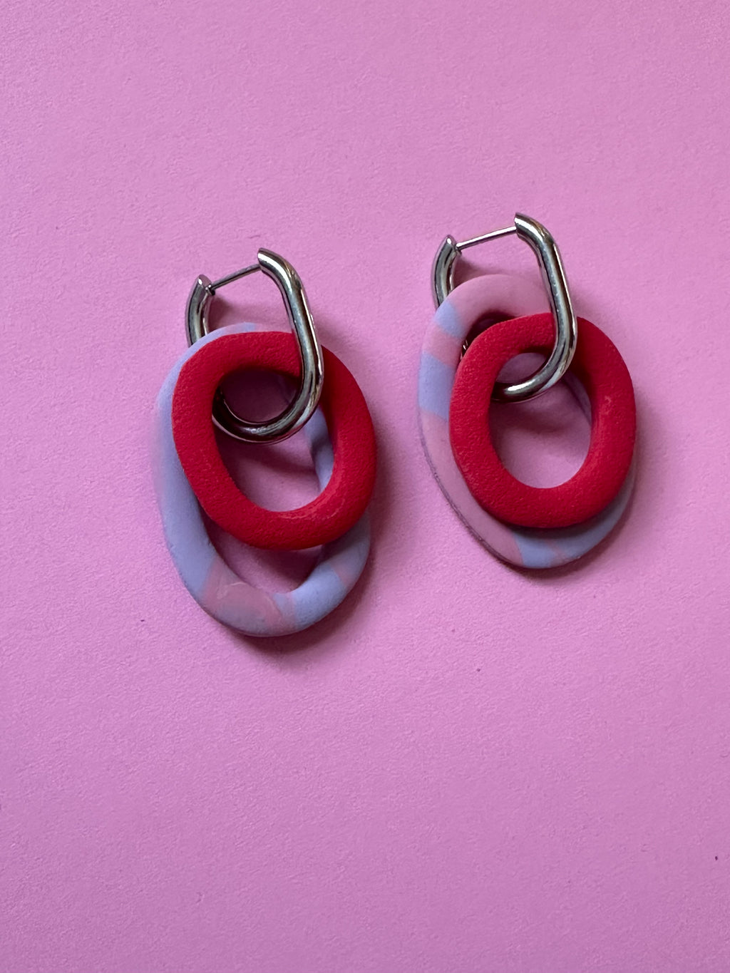 Boucles d'oreilles Mona - anneaux entrelacés rouge et blanc marbré sur fond rose