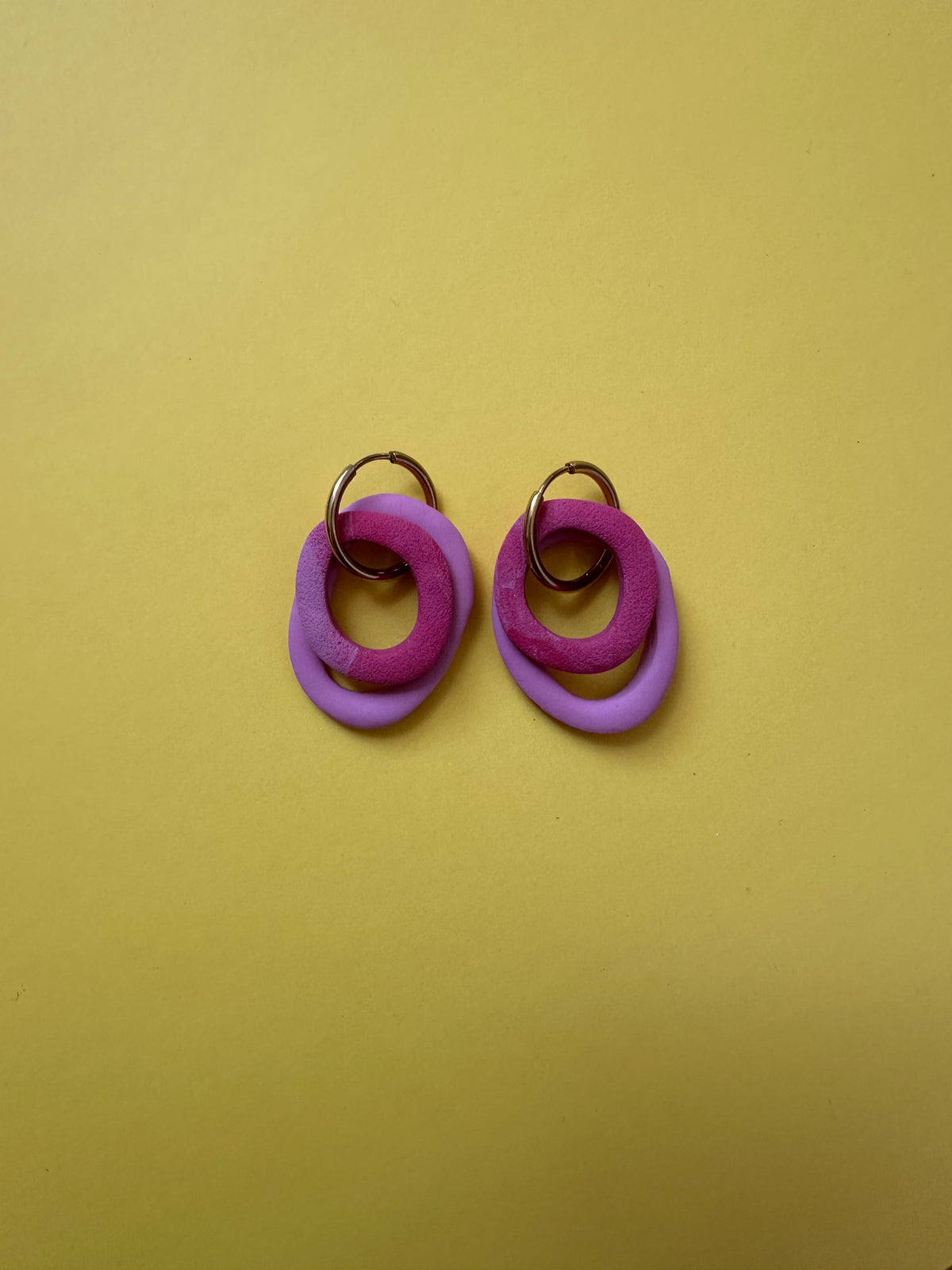 Boucles d'oreilles Nolli - anneaux violet et fuchsia entrelacés sur fond jaune